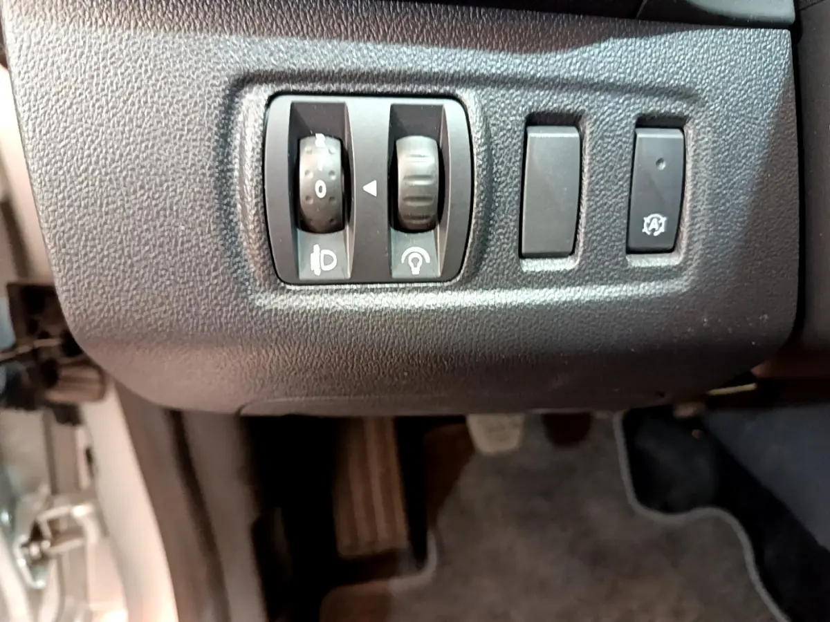 Gros plan sur les commandes de réglage des phares et arrêt automatique dans l'habitacle d'une Renault Clio Business gris clair 2019.
