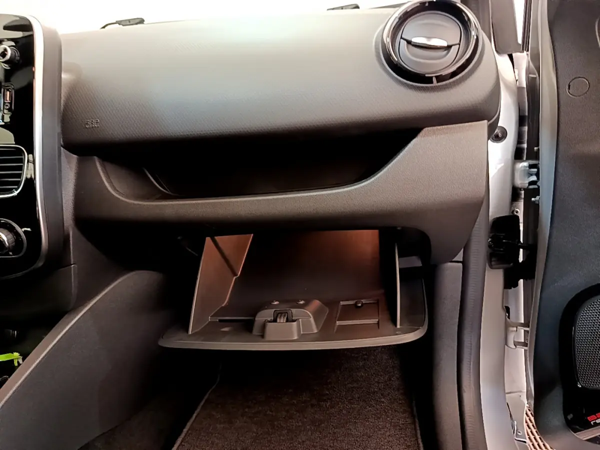 Gros plan sur la boîte à gants ouverte côté passager d'une Renault Clio Business TCe 90 gris clair, intérieur noir.