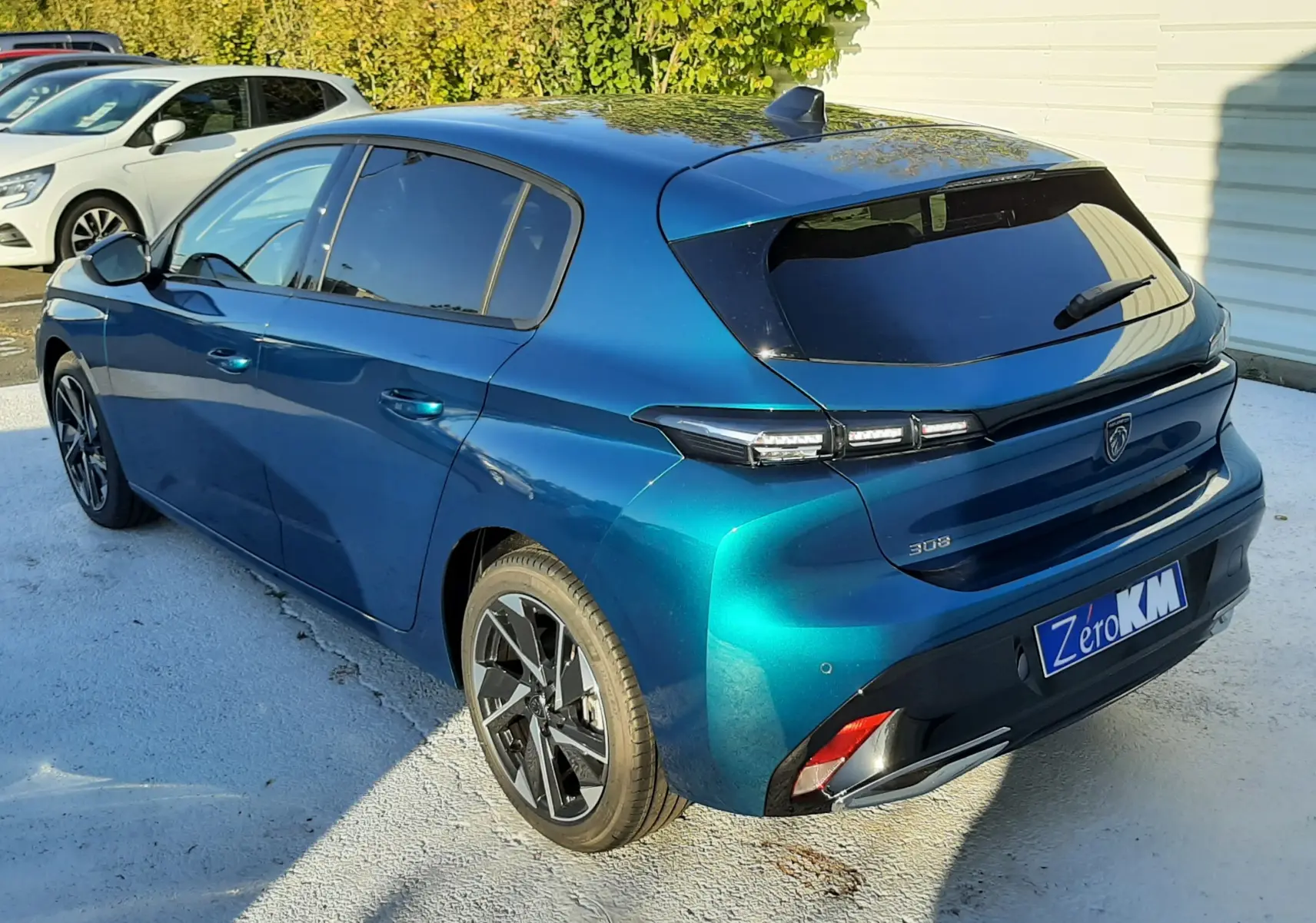 Peugeot 308 Bleu Obsession vue 3/4 arrière côté gauche, avec feux arrière LED et jantes noires biton.