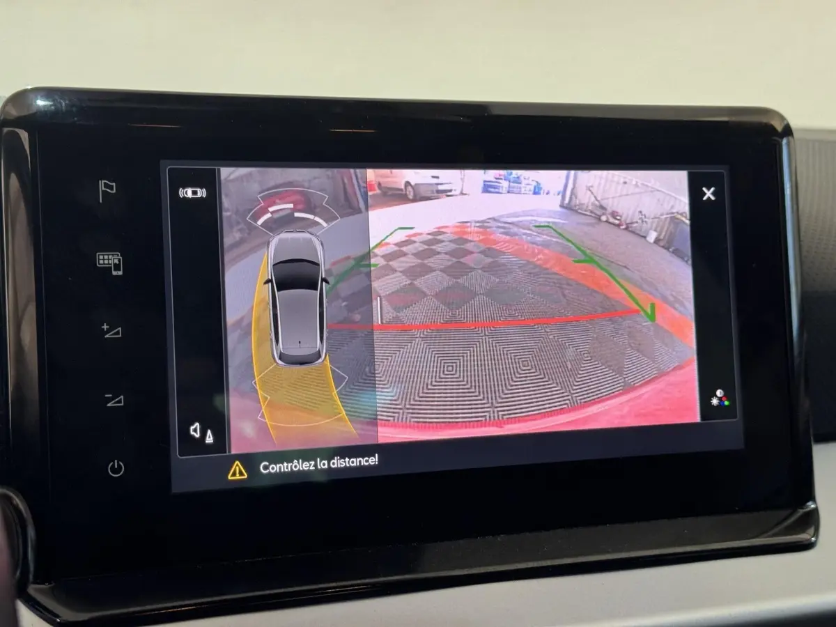 Écran tactile montrant la caméra de recul et l’aide au stationnement d’une SEAT Ibiza rouge vue de dessus.