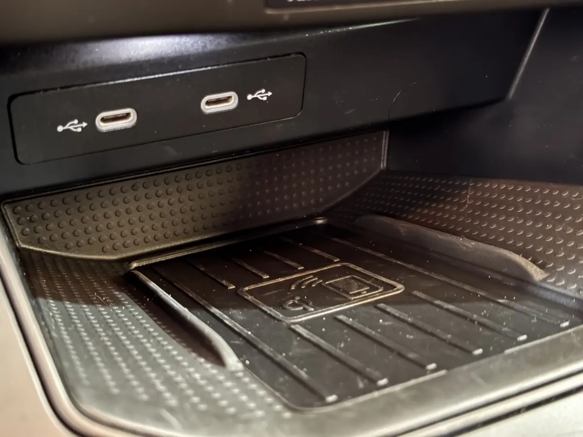 Gros plan sur la zone de recharge sans fil et ports USB dans l'habitacle noir de la SEAT IBIZA 2024.