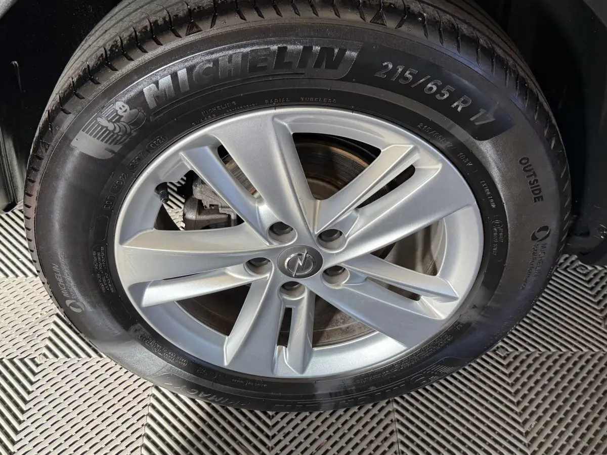 Gros plan sur la roue avant droite avec jante argentée et pneu Michelin du Opel Grandland X noir.