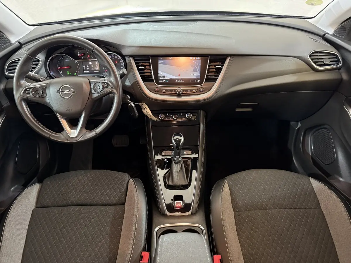 Vue intérieure frontale de l’Opel Grandland X 2021, volant cuir, écran tactile central et sièges tissu gris foncé.