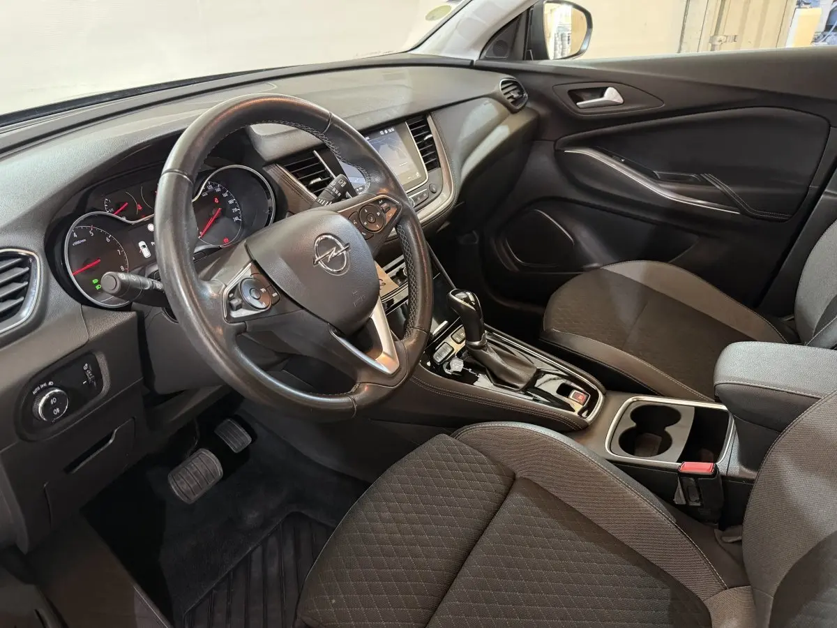 Intérieur avant droit de l’Opel Grandland X 2021, tableau de bord noir avec volant cuir et console centrale brillante.