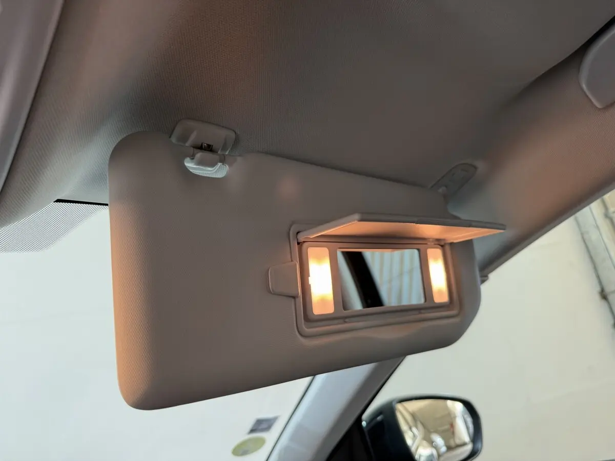 Miroir de courtoisie éclairé sur pare-soleil côté conducteur de l’Opel Grandland X noir, vue intérieure avant gauche.