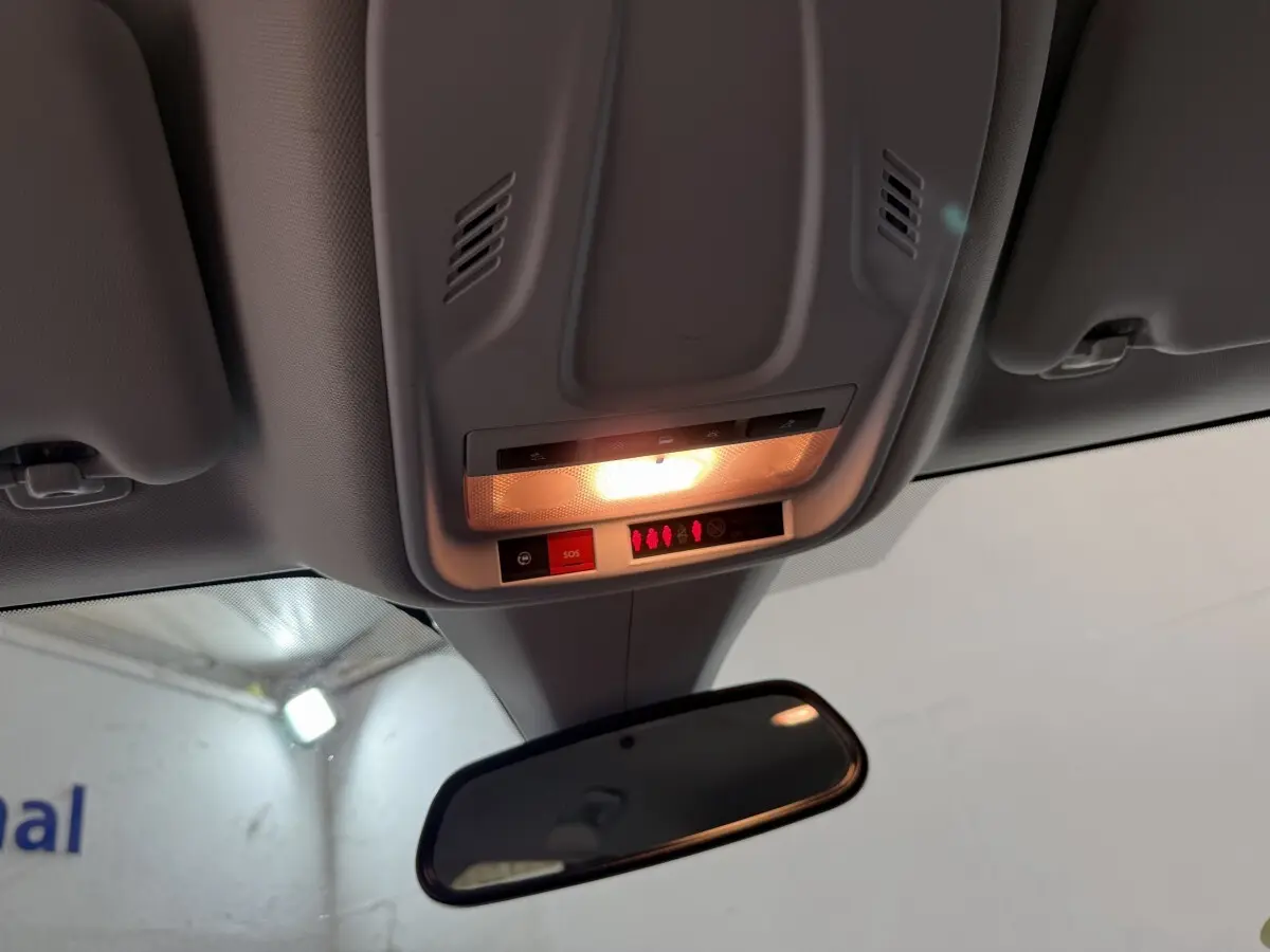 Plafonnier intérieur allumé avec bouton SOS et rétroviseur central dans un Opel Grandland X noir, vue de l'avant cabine.