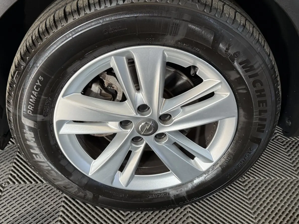 Gros plan sur la jante argentée à cinq branches du pneu Michelin d’un Opel Grandland X noir.