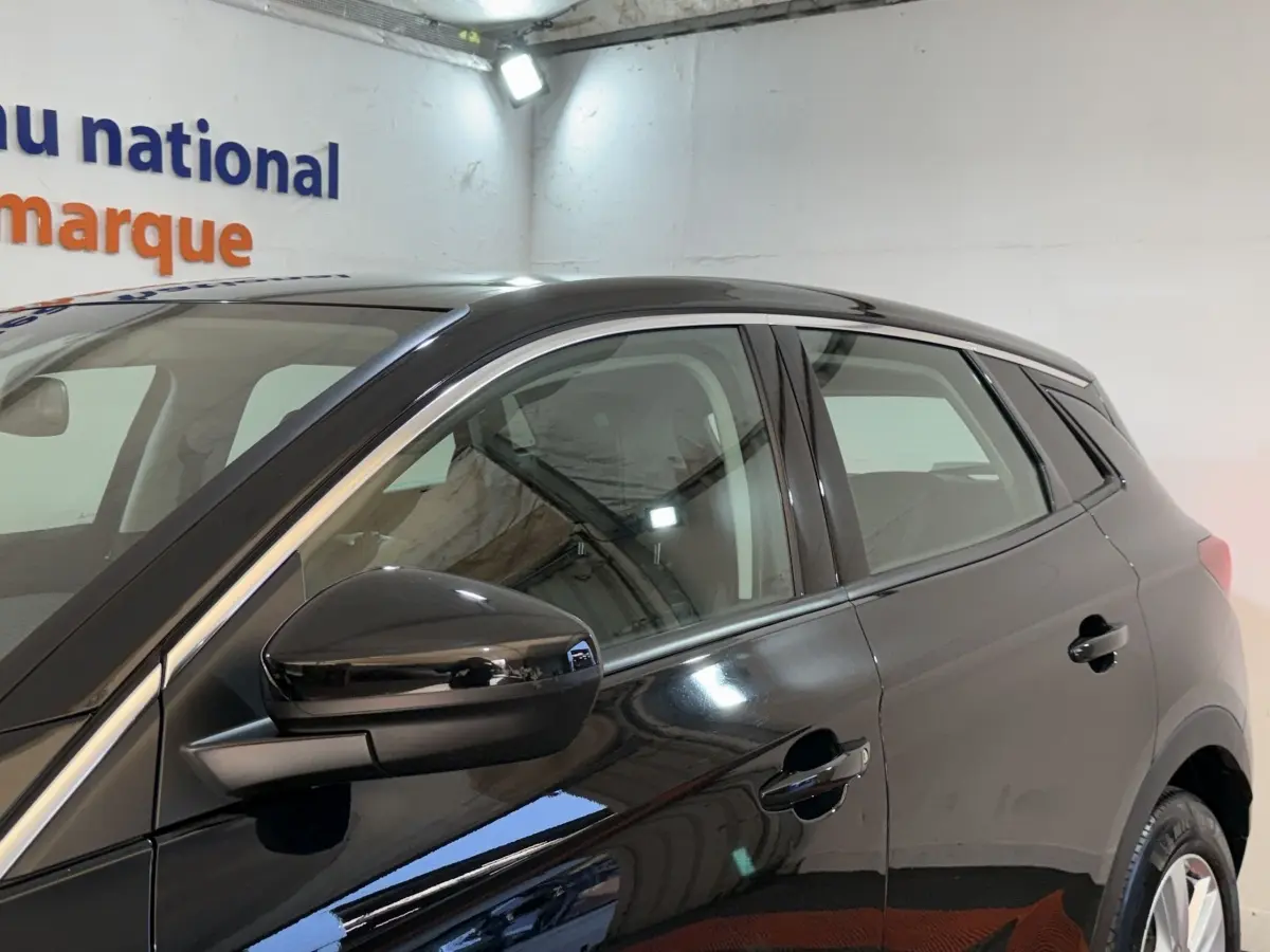 Vue latérale côté gauche d'un Opel Grandland X noir brillant, mettant en valeur la porte et le rétroviseur extérieur.