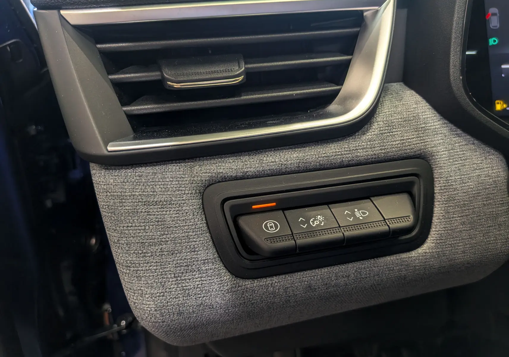 Détail intérieur côté gauche de la Renault Clio V 2025 Bleu Iron montrant les commandes d’éclairage et la sortie d’air.