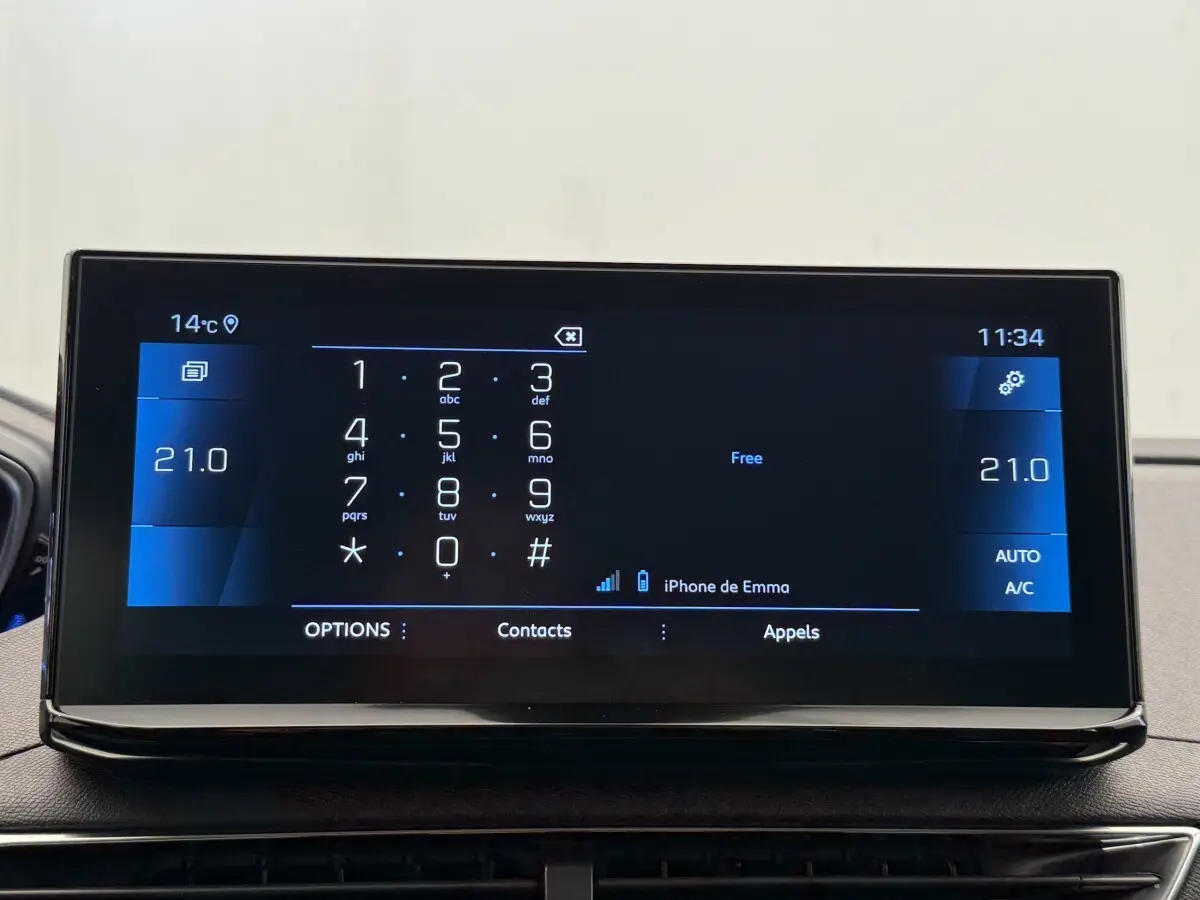 Écran tactile central du Peugeot 3008 gris foncé, affichant le clavier téléphonique et la température à 21°C.