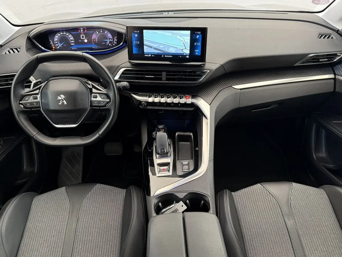 Vue intérieure avant du Peugeot 3008 gris foncé, avec tableau de bord numérique et écran tactile central.