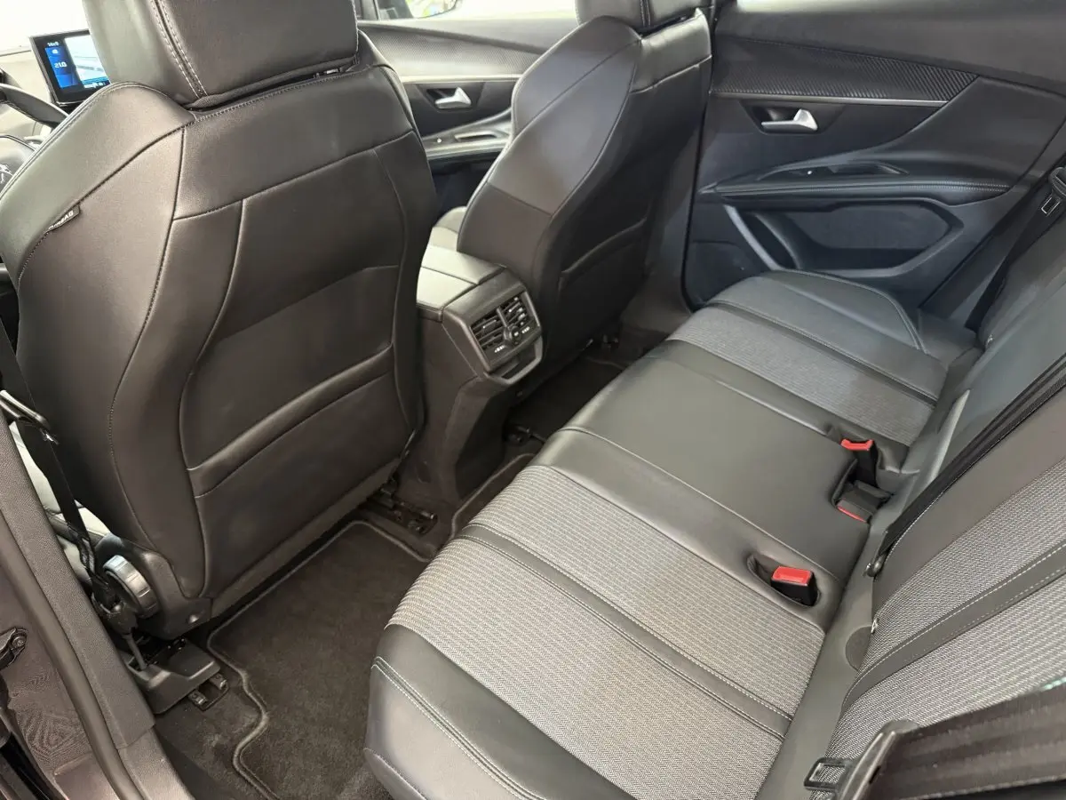 Vue intérieure arrière côté droit du Peugeot 3008 2022, sièges en cuir et tissu gris foncé avec aérateurs centraux.