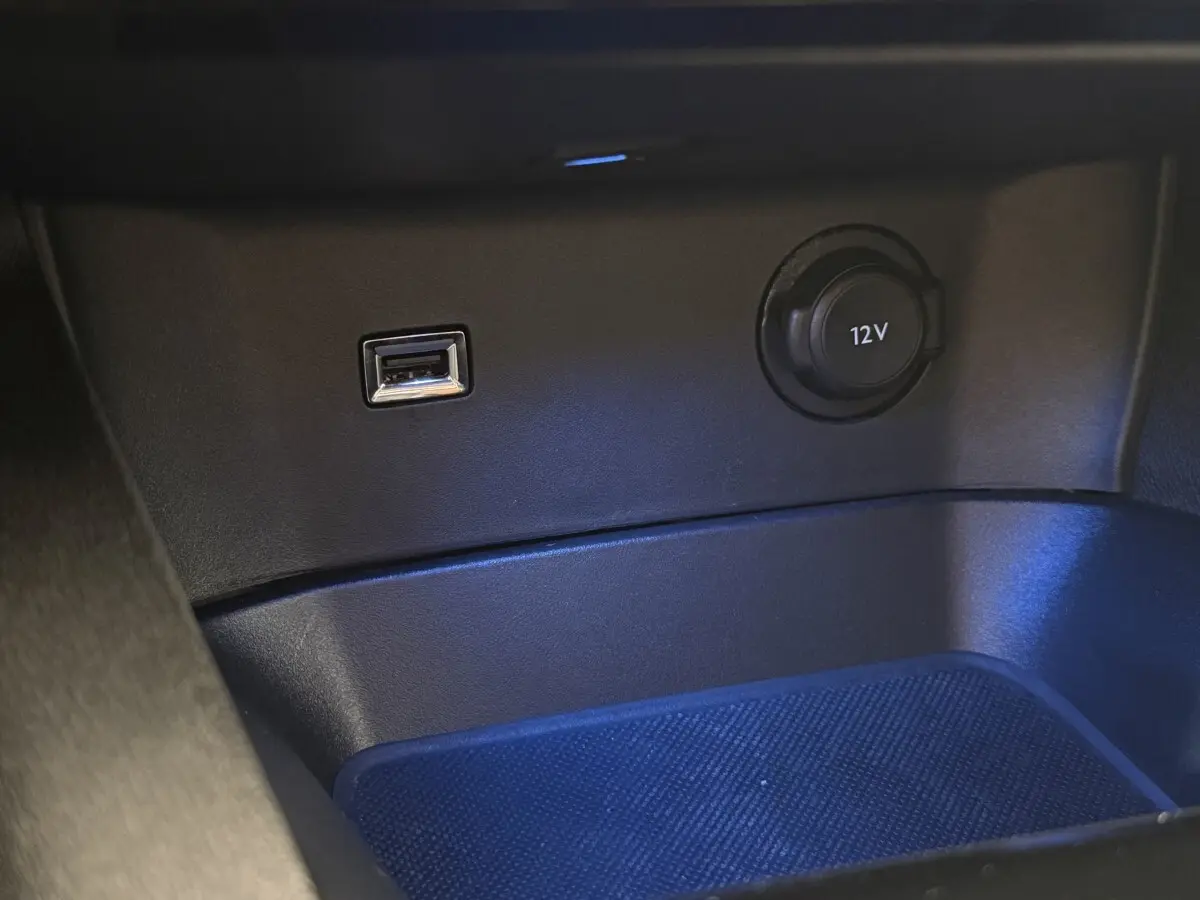 Gros plan sur la prise USB et la prise 12V dans le rangement avant du Peugeot 3008 gris foncé PureTech 2022.