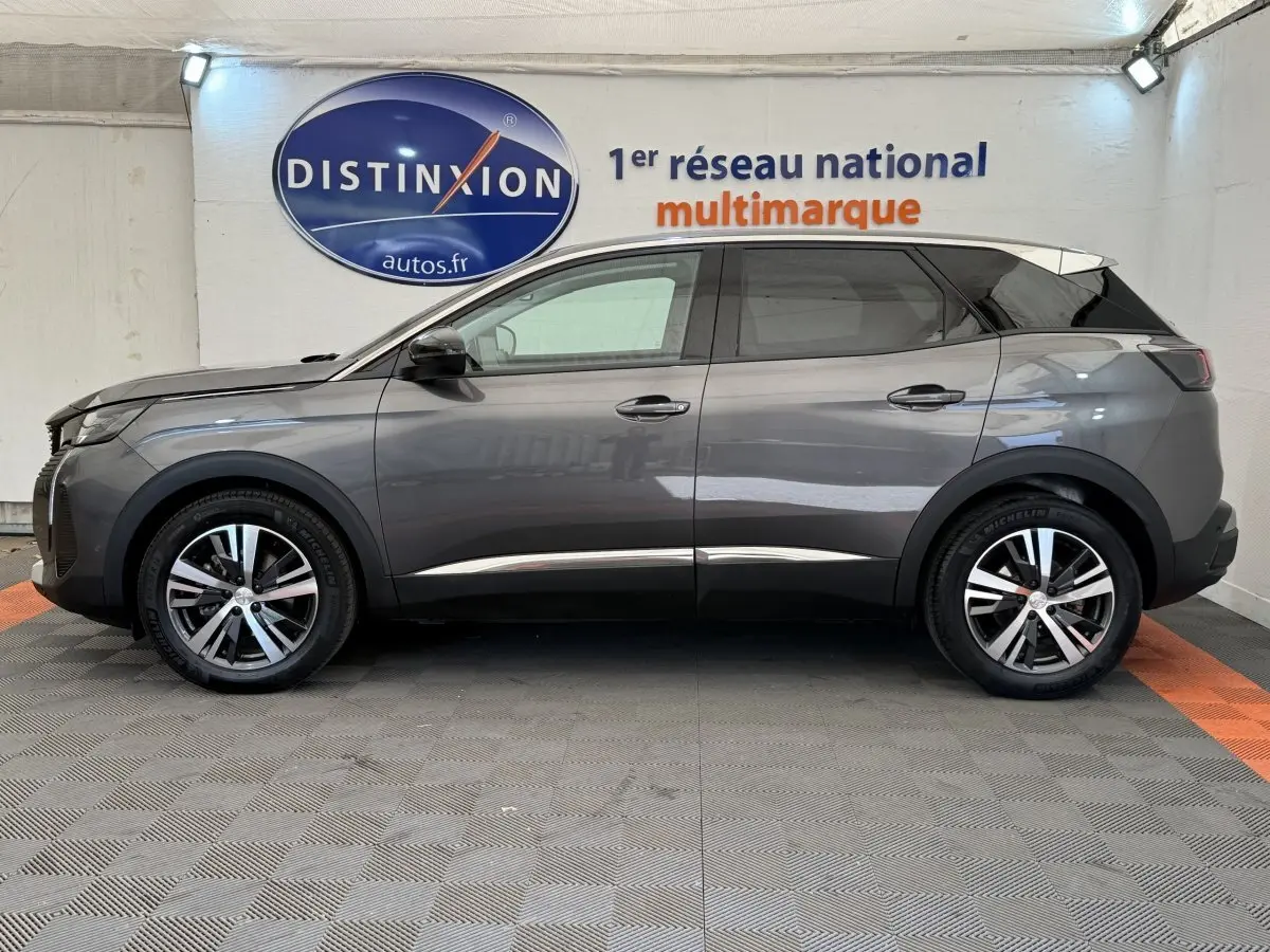 Vue latérale droite d'un Peugeot 3008 gris foncé 2022 dans un showroom avec logo Distinxion en arrière-plan.