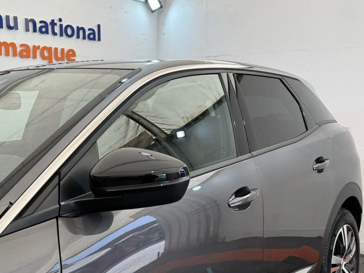 Vue côté gauche avant d’un Peugeot 3008 gris foncé avec rétroviseur noir brillant et poignées ton caisse.