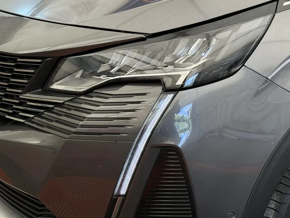 Gros plan sur le phare avant droit gris foncé du Peugeot 3008 avec signature lumineuse verticale LED distinctive.