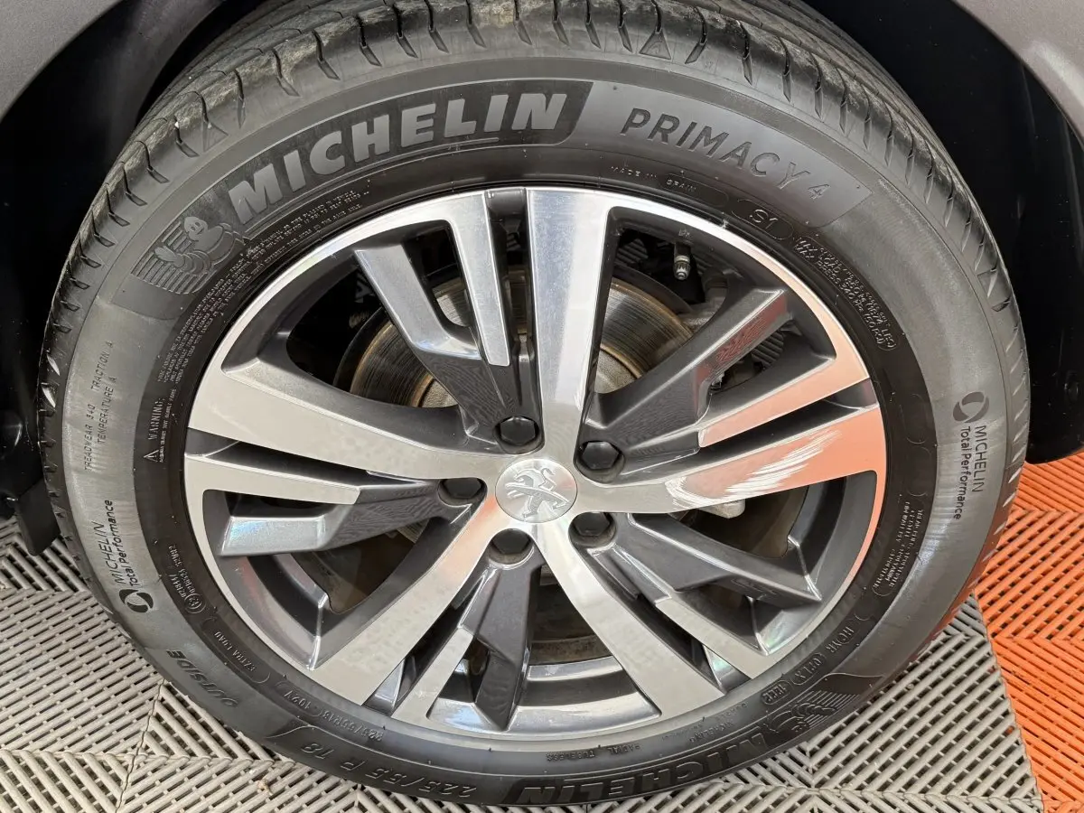 Gros plan sur la jante alliage gris foncé et le pneu Michelin d’un Peugeot 3008 PureTech 130 Allure.
