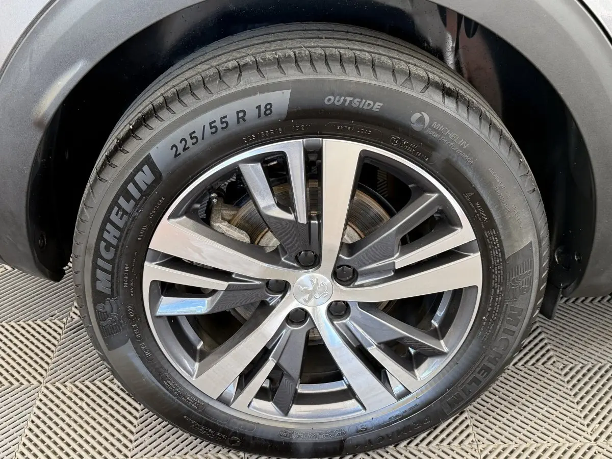 Gros plan sur la roue avant droite du Peugeot 3008 gris foncé avec jante alliage et pneu Michelin 18 pouces.