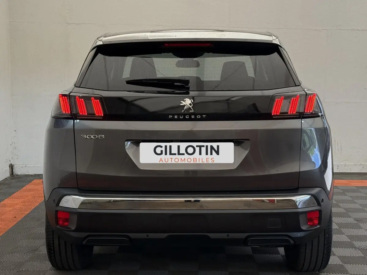 Vue arrière d’un Peugeot 3008 gris foncé avec feux LED caractéristiques et hayon noir brillant.
