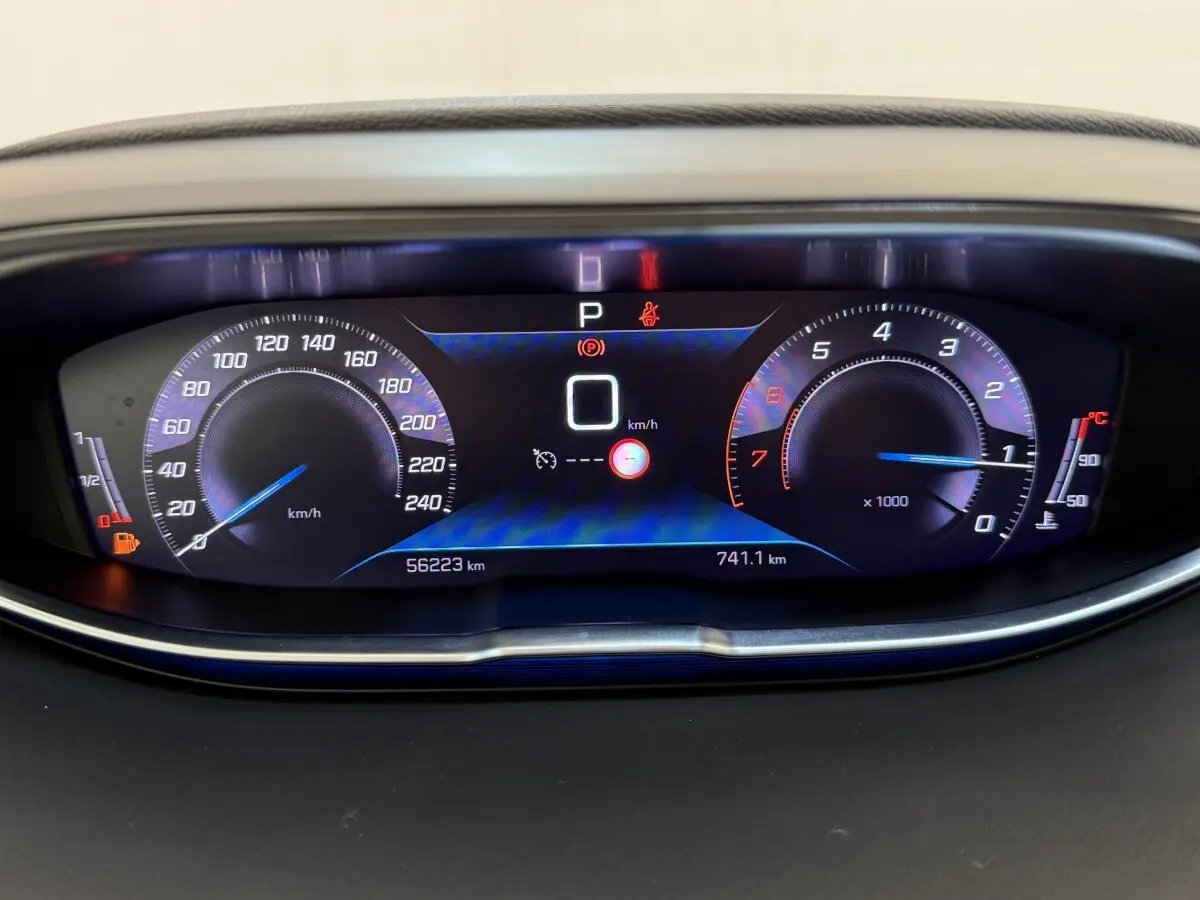 Vue rapprochée du tableau de bord numérique du Peugeot 3008 gris foncé, affichant la vitesse à 0 km/h et le compte-tours.
