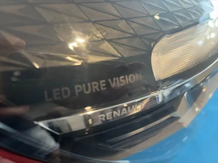 Gros plan sur le phare avant droit rouge flamme métal de la Renault Clio V avec inscription LED Pure Vision.
