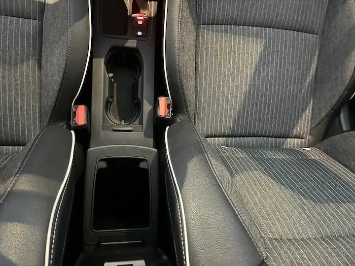 Vue rapprochée de la console centrale et des sièges en tissu gris rayé de la Renault Clio V Intens 2021.