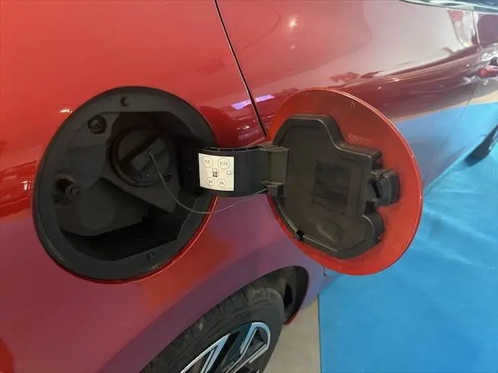Détail de la trappe à carburant rouge flamme métal côté gauche arrière d'une Renault Clio V 1.0 TCE 90 CH Intens 2021.