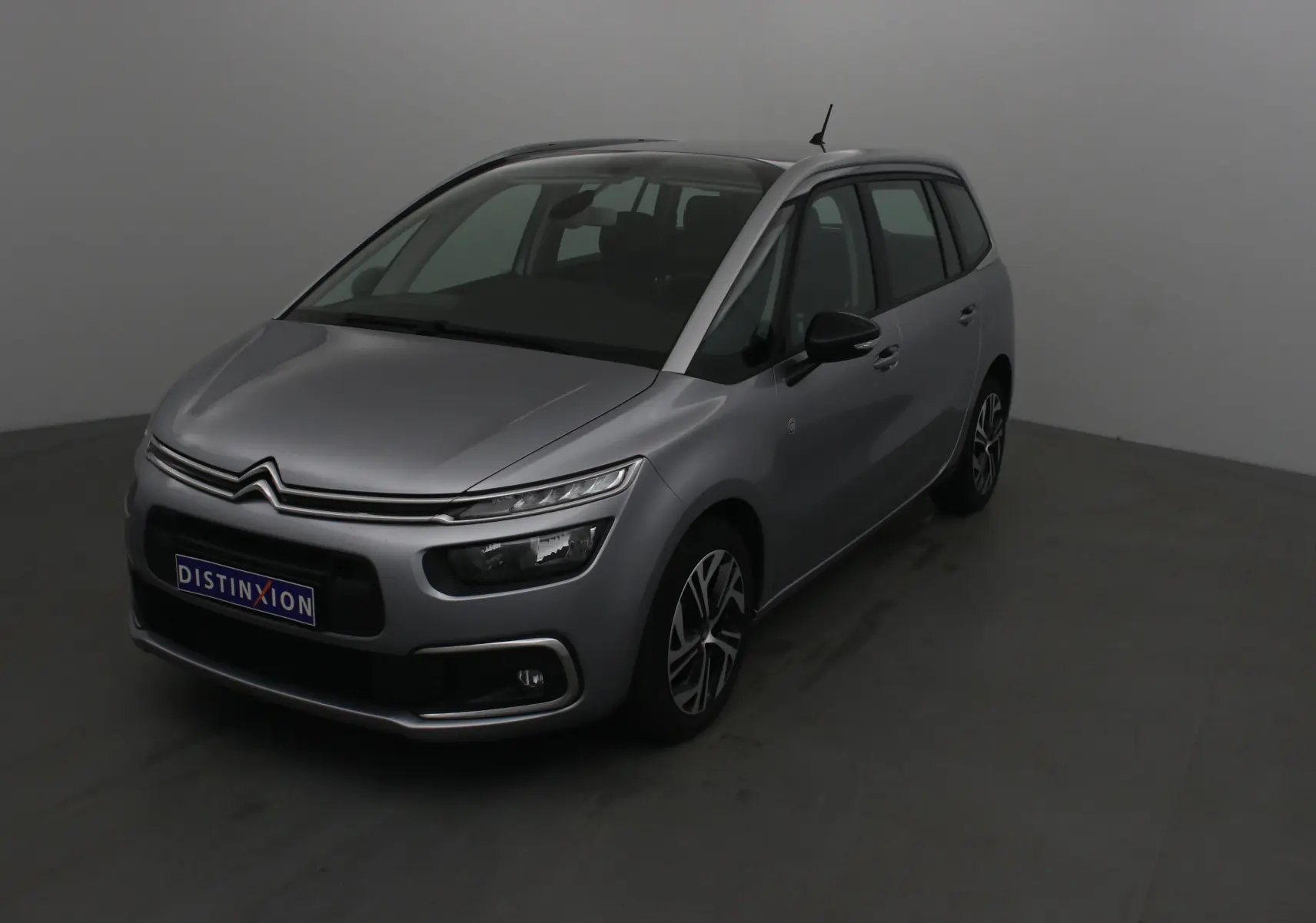 Citroën Grand C4 Spacetourer gris Artense vu en 3/4 avant droit avec ses phares distinctifs et jantes stylées.