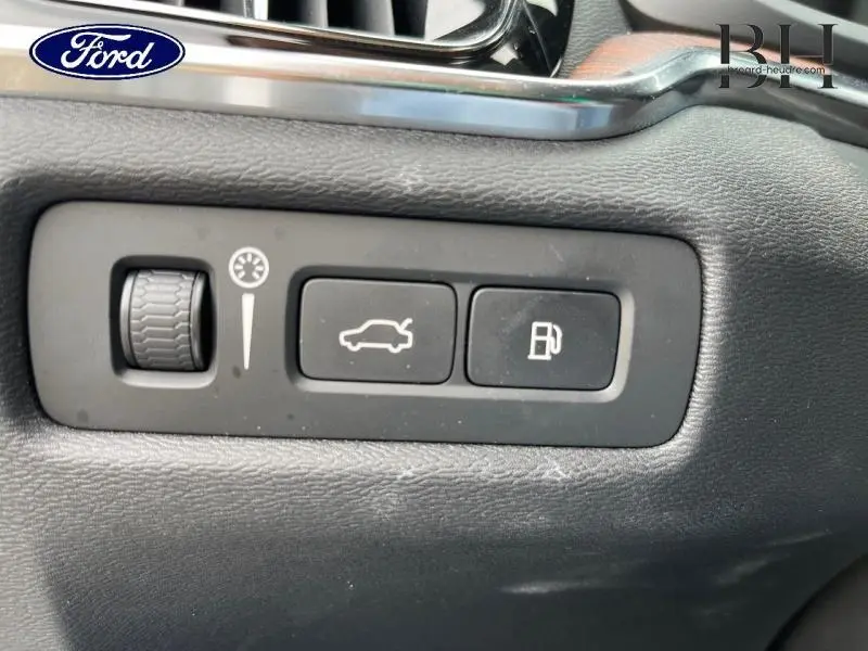 Gros plan sur les commandes d'ouverture du coffre et de la trappe à carburant d'un Volvo V60 gris Savile Métallisé.