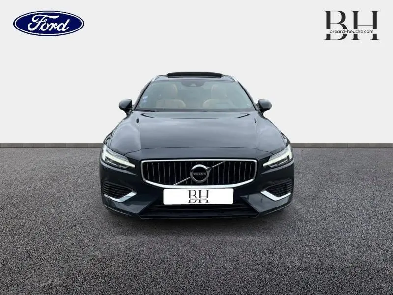 Vue frontale d'une Volvo V60 T8 hybride gris Savile métallisé avec calandre verticale et phares LED distinctifs.