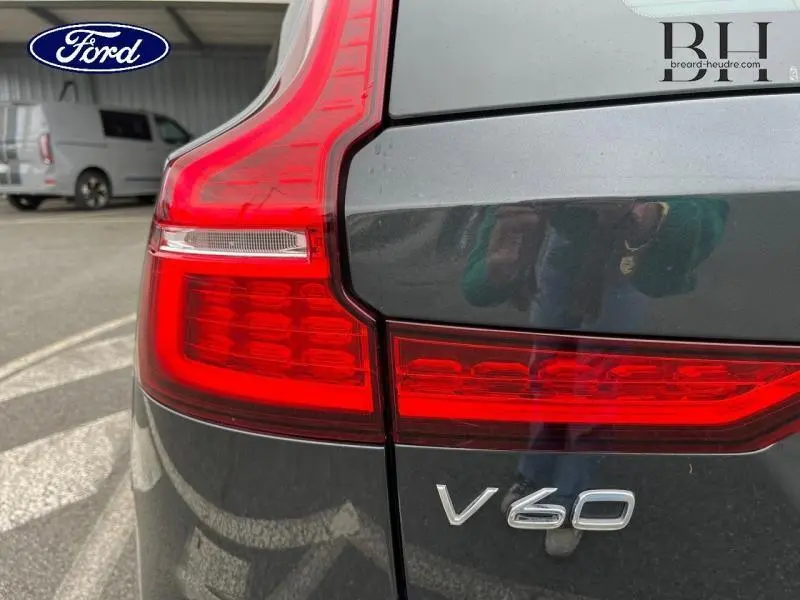 Gros plan sur le feu arrière droit rouge d'un Volvo V60 gris Savile Métallisé avec logo et badge arrière visibles.