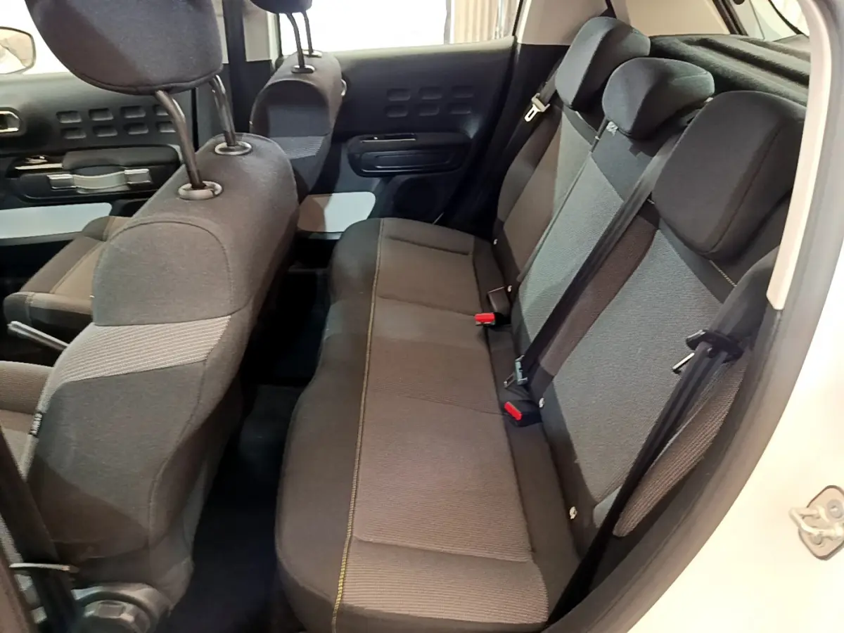 Vue intérieure côté droit montrant la banquette arrière grise et noire de la Citroën C3 blanche 2019.
