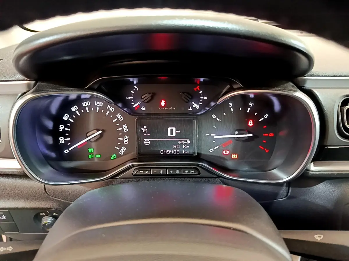 Vue rapprochée du tableau de bord de la Citroën C3 blanche de 2019, affichant le compteur et les voyants allumés.