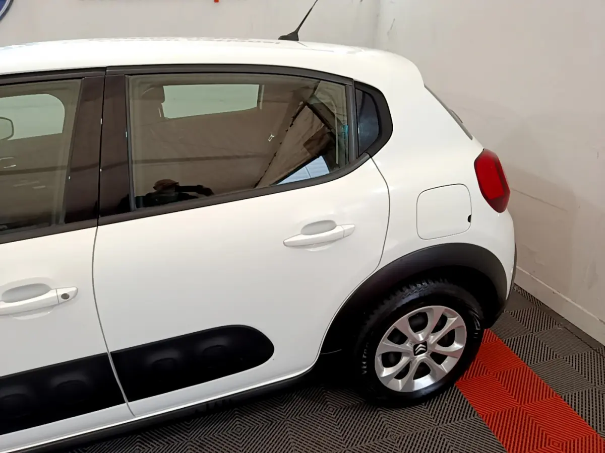 Vue côté droit arrière d'une Citroën C3 blanche avec protections latérales noires et jantes alliage.