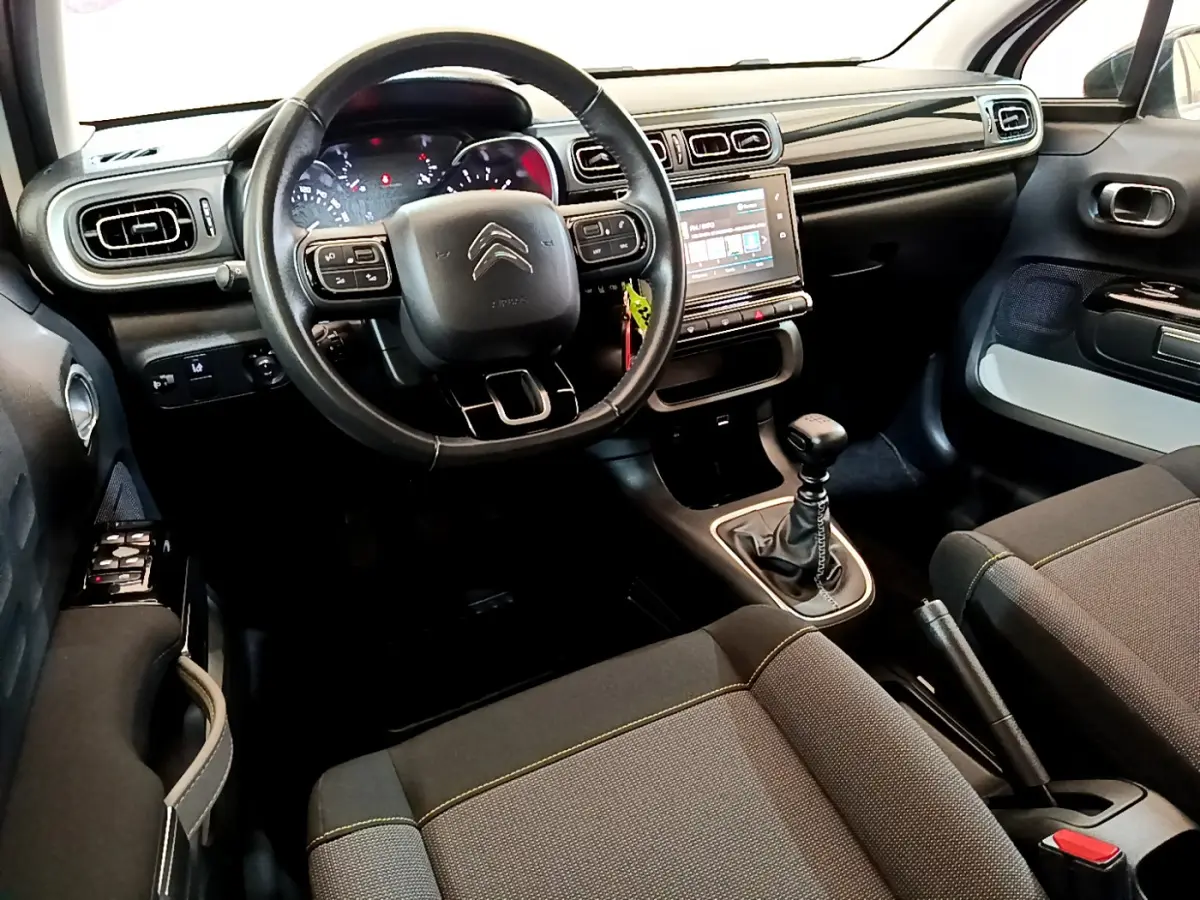 Intérieur avant de la Citroën C3 blanche 2019, volant cuir, écran tactile 7 pouces et boîte manuelle visible.