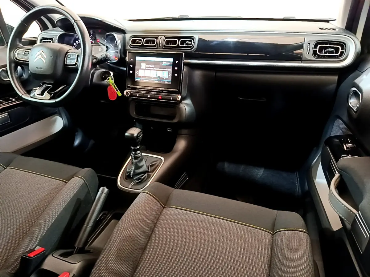 Intérieur avant de la Citroën C3 blanche 2019, tableau de bord noir avec écran tactile et volant cuir multifonctions.