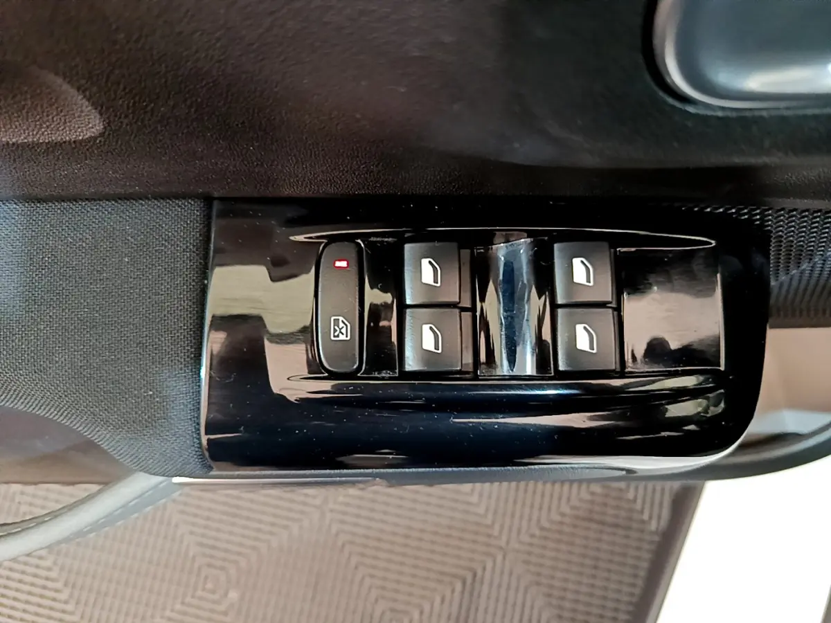 Gros plan sur les commandes de lève-vitres électriques côté conducteur d'une Citroën C3 blanche, finition Shine Business.