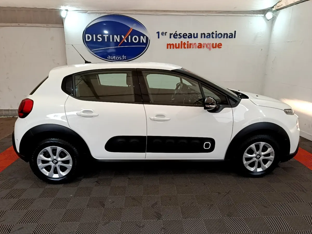 Profil côté gauche d'une Citroën C3 blanche de 2019 avec protections latérales noires et jantes alliage.