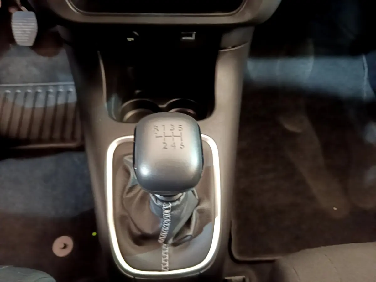 Le levier de vitesses manuel noir de la Citroën C3 PureTech 110 vue de dessus, entouré d'un cadre argenté.