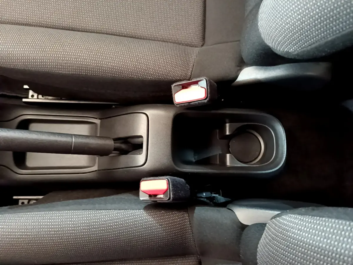 Vue plongeante sur la console centrale noire et les sièges tissu gris foncé de la Citroën C3 PureTech 2019.