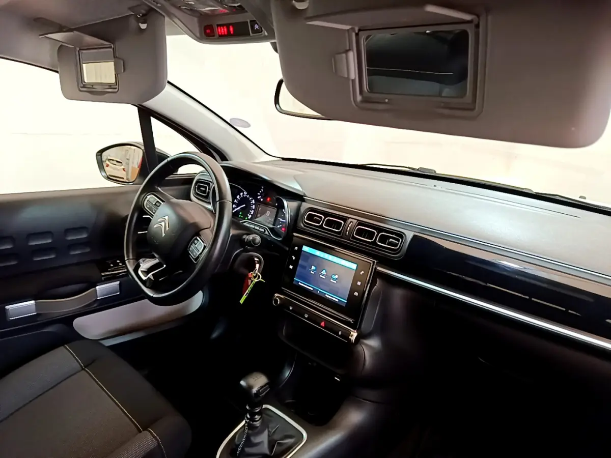 Vue intérieure côté conducteur de la Citroën C3 blanche 2019 avec tableau de bord moderne et écran tactile central.