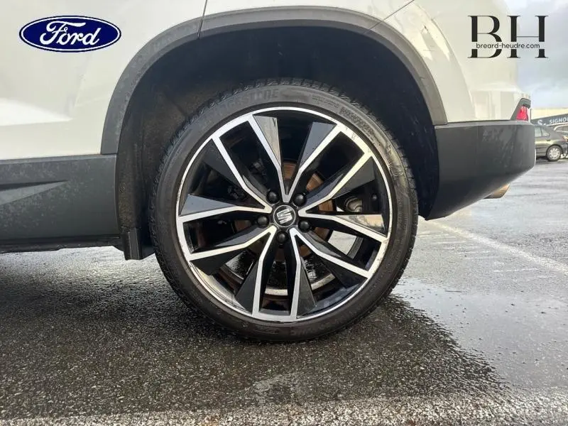 Gros plan sur la roue avant droite d’un SEAT Ateca blanc Nevada Métal avec jante alliage noire et argent.