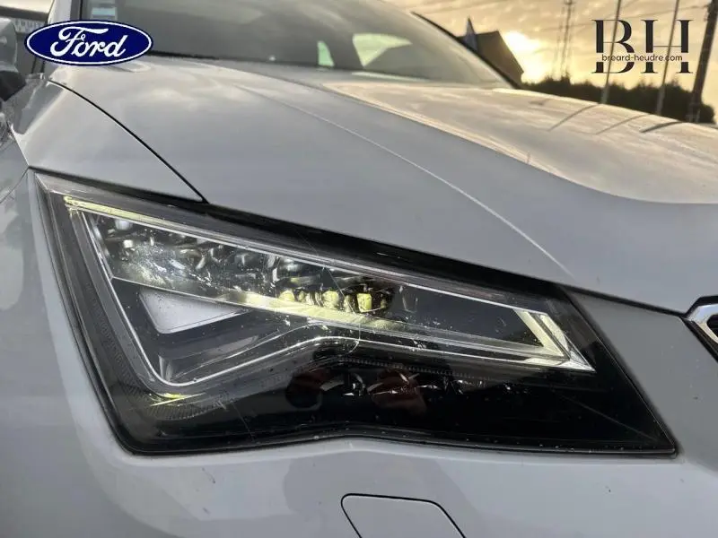 Gros plan sur le phare avant gauche du SEAT Ateca blanc Nevada Métal avec détails LED et contours nets.