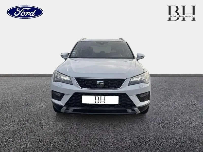 Vue avant d'un SEAT Ateca blanc Nevada Métal 2020 avec calandre noire et phares LED allumés sur fond neutre.