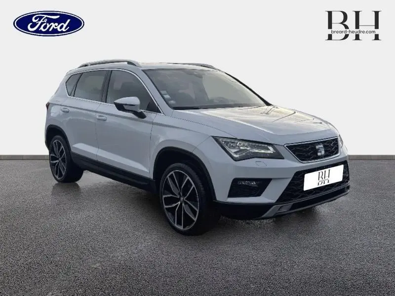 SUV SEAT Ateca blanc Nevada métal en vue 3/4 avant droit, avec jantes alliage et toit ouvrant panoramique.