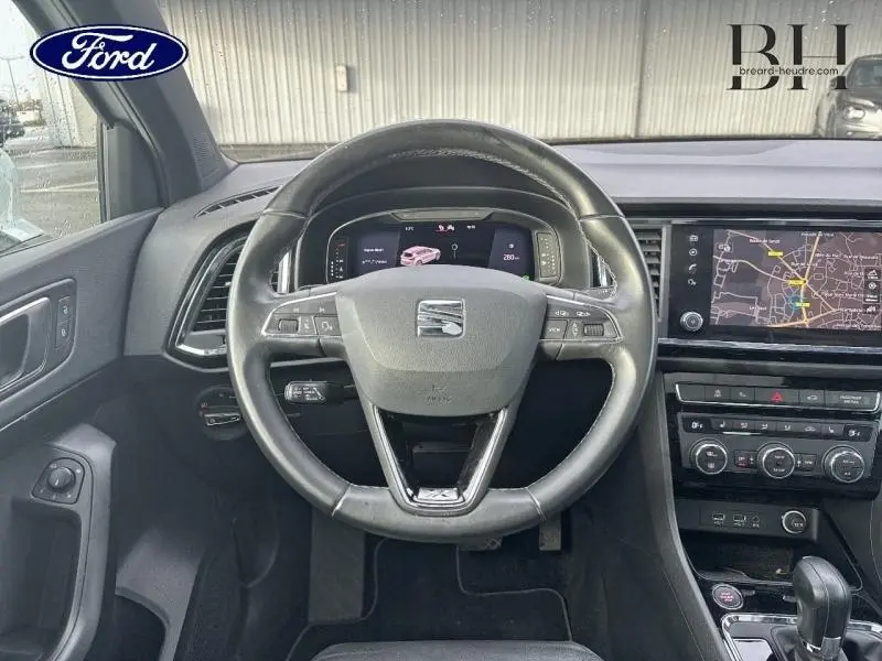 Vue intérieure centrée sur le volant cuir multifonction d’un SEAT Ateca 2020 avec écran tactile et tableau de bord numérique.