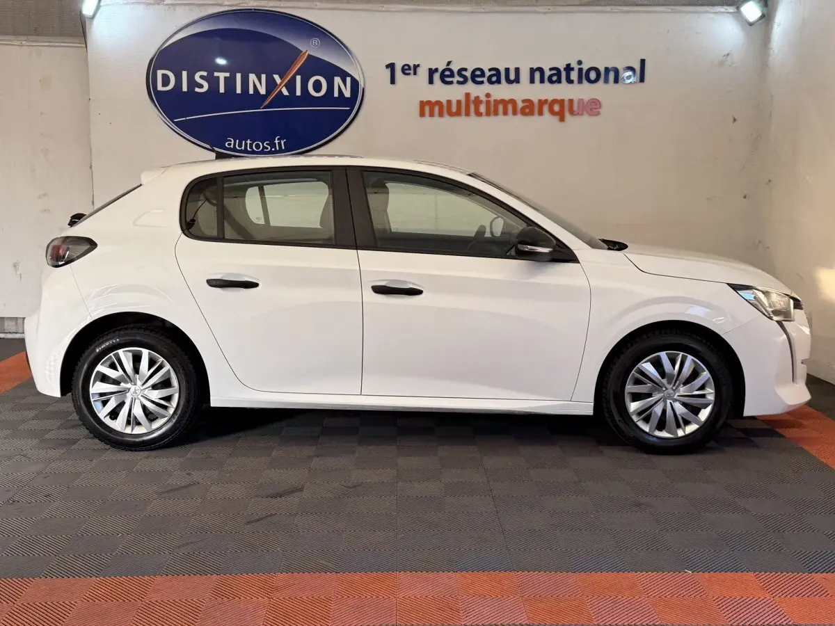 Vue latérale droite d'une Peugeot 208 blanche de 2020, avec jantes alliage et poignées de porte noires.