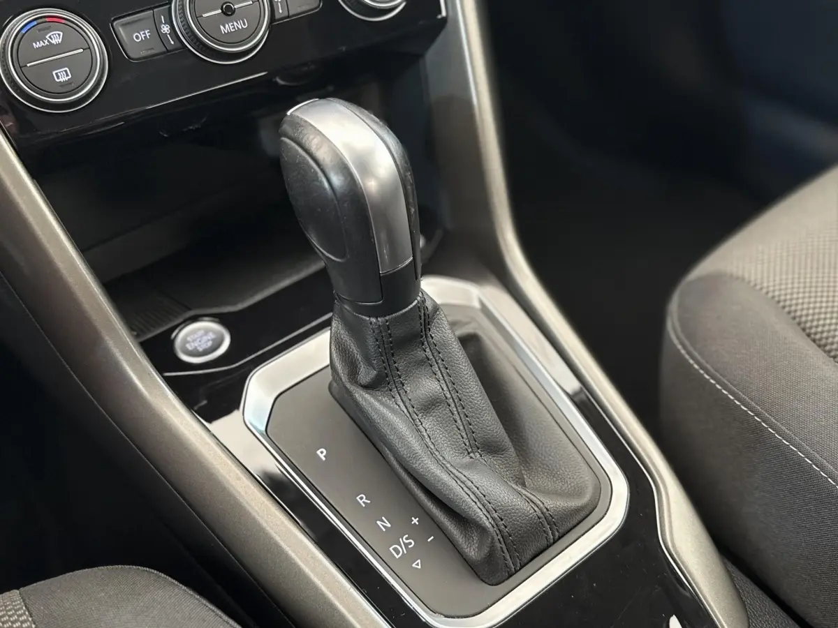 Le levier de vitesses automatique noir et argenté du Volkswagen T-Roc 2.0 TDI, vue rapprochée de l'intérieur.