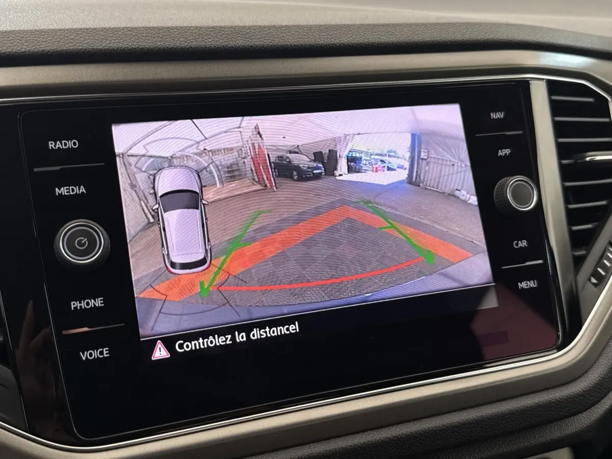 Écran tactile intérieur affichant la caméra de recul du Volkswagen T-Roc bleu avec guidage de trajectoire coloré.