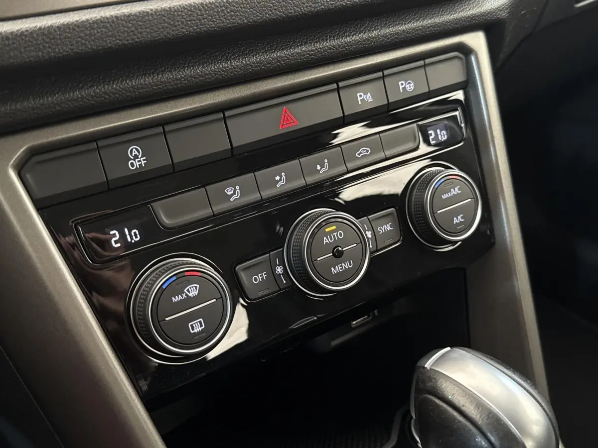 Gros plan sur la console centrale du Volkswagen T-Roc 2020, avec commandes de climatisation et levier de boîte automatique.
